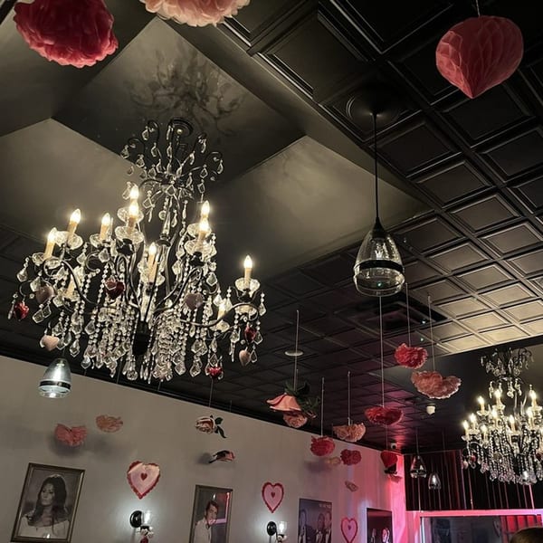 Mille Luci Pizzeria's interior with ornate chandeliers, dark ceiling, and heart decorations for Valentine's Day.
